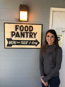 A participant poses by the Food Pantry entry sign.