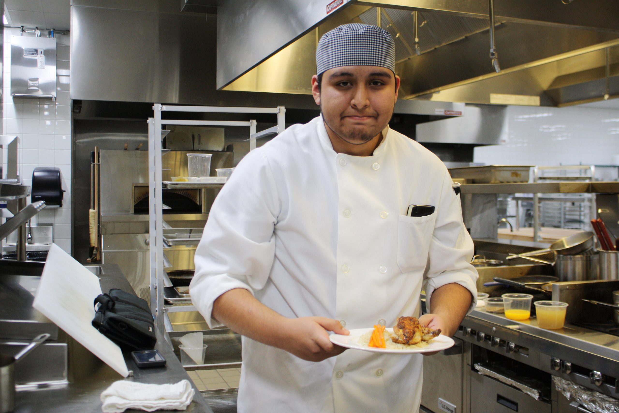 A Middle College student prepares a meal in the kitchens at Madison College