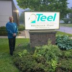 Nathan, WIOA Dislocated Worker Program participant, stands next to Teel Plastics sign.